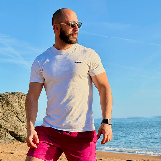 Kevin, fondateur de GORILLE, portant un t-shirt brodé GORILLE sur la plage